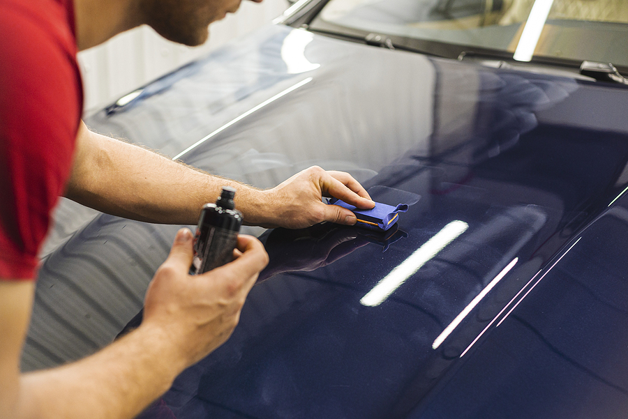 Technician applies ceramic coating with an applicator pad to a dark blue car hood in Halifax, NS.| Halifax Waterfront | paint prep | microfiber leveling | hydrophobic protection