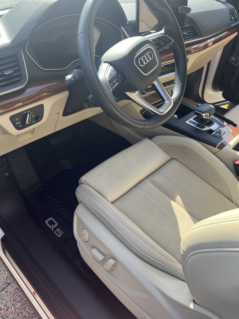 Audi Q5 driver area cleaned as part of Packages service, with leather seat, dash, and console wiped down.| none | leather seat cleaning | dashboard cleaning | interior wipe down