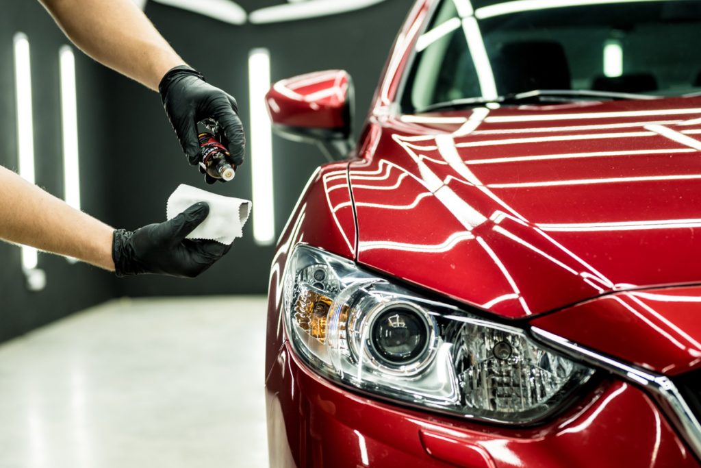 Technician applies ceramic coating to a red car hood with a microfiber towel in Halifax, NS.| Halifax Waterfront | paint prep | microfiber leveling | hydrophobic protection