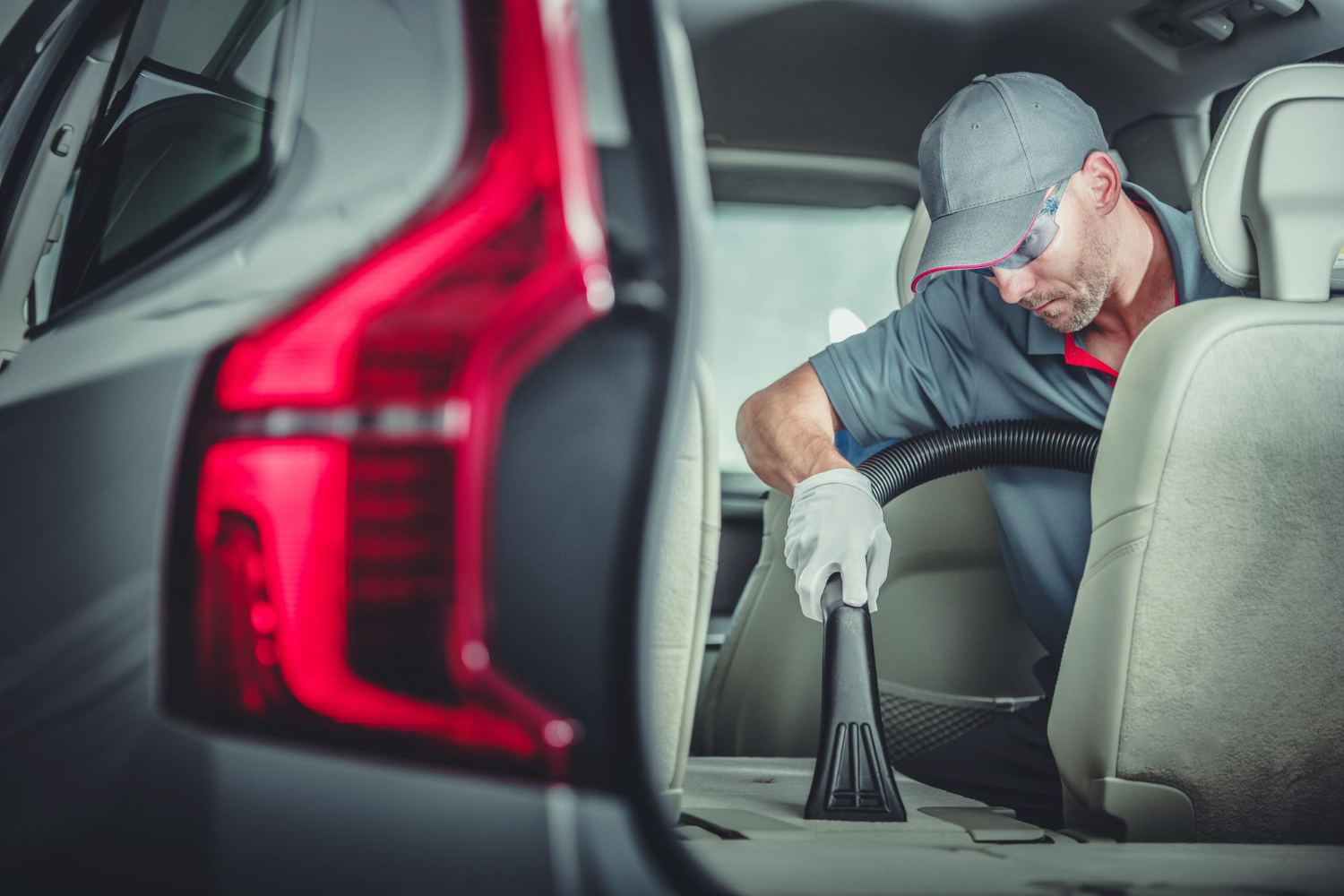 Technician vacuums the back seat area for interior detailing in Dartmouth, removing dirt and debris.| Halifax Harbour | deep vacuum | upholstery cleaning | odour removal